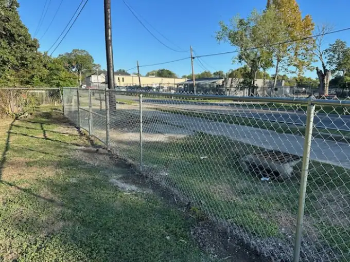 Galvanized commercial chain link fence with walk gate along a Pasadena roadside